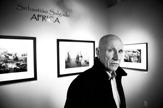 The celebrated Brazilian photographer Sebastião Salgado, with his works at the Peter Fetterman Gallery in Santa Monica, Calif. on May 13, 2009. (Kevin Scanlon/The New York Times)