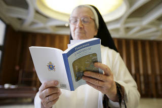 FILE PHOTO: A nun reads Pope Francis' new encyclical titled 'Laudato si' at the Vatican