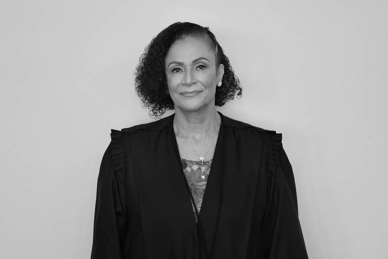 Imagem em primeiro plano mostra mulher negra posando para foto usando uma toga