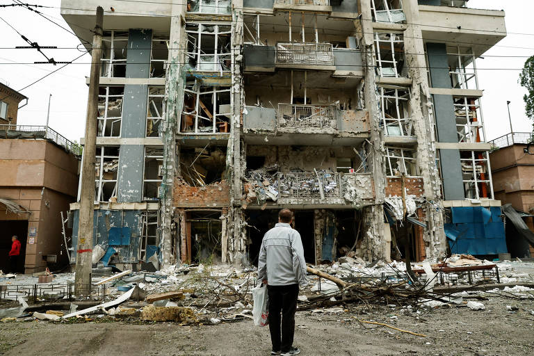 Morador de Kiev, Ucrânia, observa prédio de apartamentos danificado por um ataque de drone russo