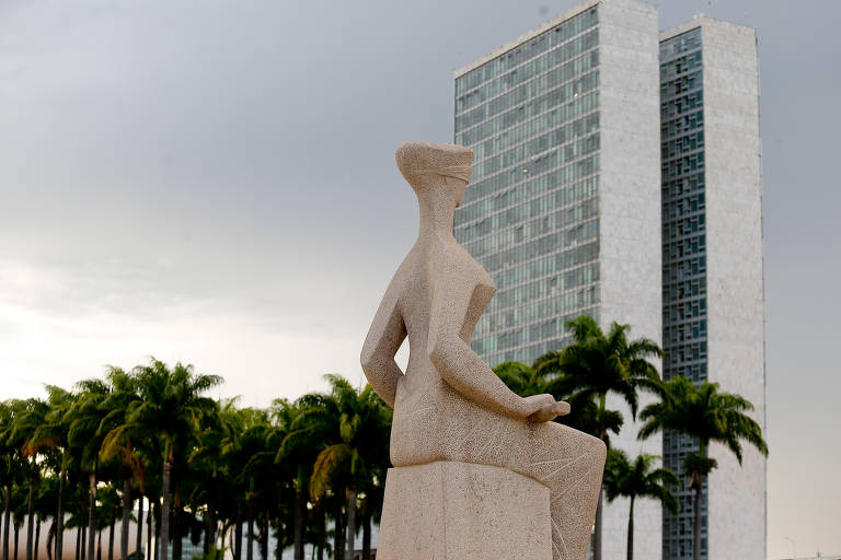 Estátua 'A Justiça' em primeiro plano. Ao fundo, a torre do Congresso Nacional e algumas palmeiras