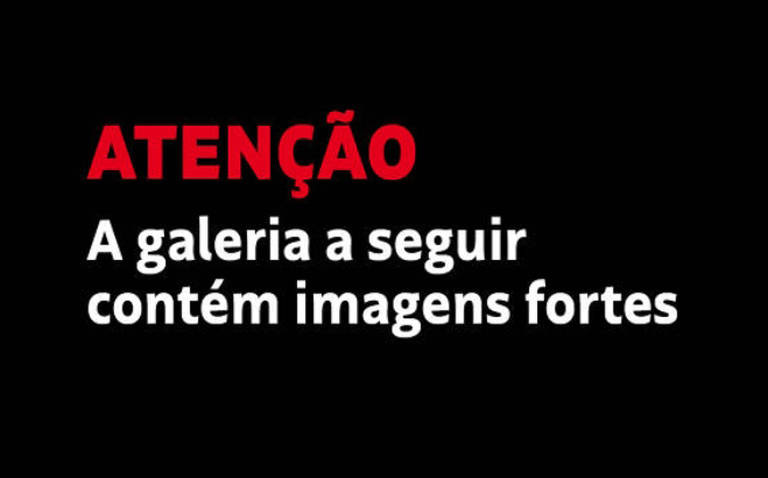 A imagem apresenta um fundo preto com texto em duas cores. A palavra 'ATENÇÃO' está em vermelho e em destaque, enquanto a frase 'A galeria a seguir contém imagens fortes' está em branco. O texto é centralizado na imagem.