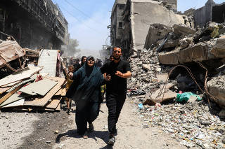 Palestinians evacuate in the aftermath of an Israeli strike on a house, in Gaza City