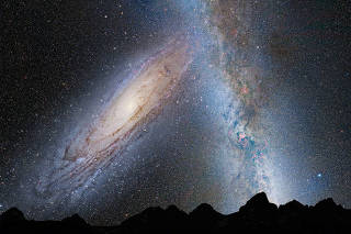 An illustration shows a stage in the potential merger between the Milky Way galaxy and the neighboring Andromeda galaxy