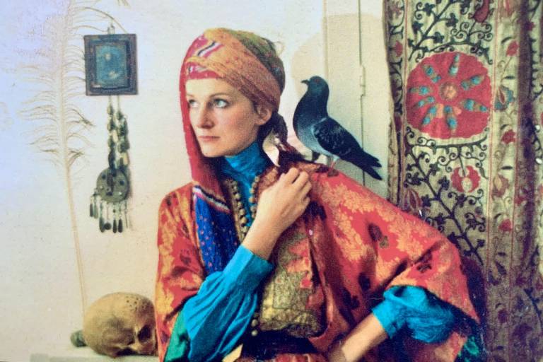 Mulher com turbante e pássaro no ombro