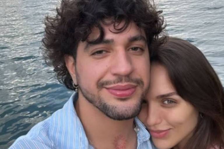 Em foto colorida, o casal aparece abraçado