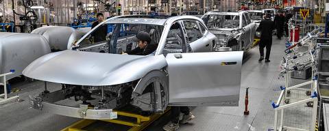 Employees work on electric cars at a Zeekr factory in Meishan Island in Ningbo, in China's eastern Zhejiang Province on April 18, 2025. (Photo by HECTOR RETAMAL / AFP)
