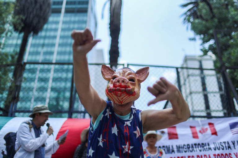 Homem usa uma máscara de porco em ato em frente à embaixada do México em Los Angeles; manifestantes vãos às ruas de Los Angeles pelo quarto dia contra a política de imigração do presidente Donald Trump