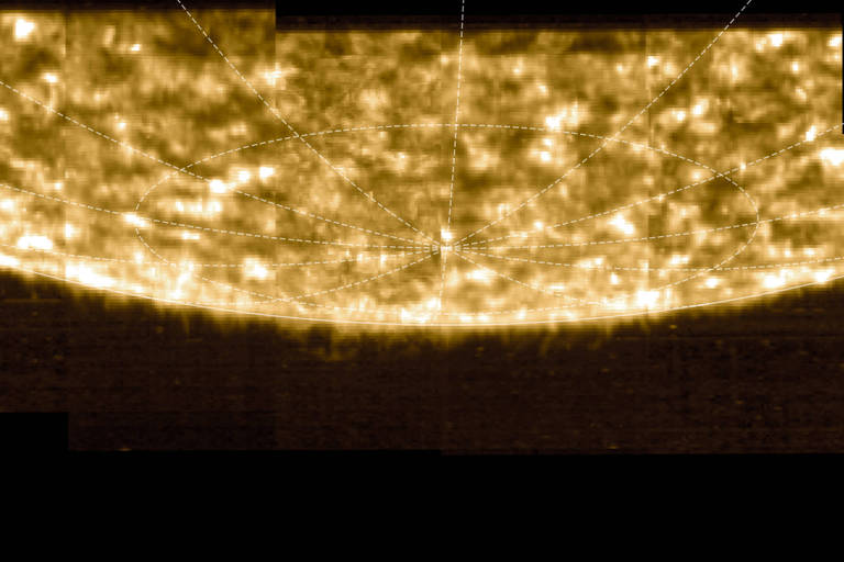 A imagem mostra uma representação da superfície do Sol, com uma textura brilhante e irregular. A iluminação é intensa, com áreas mais brilhantes e outras mais escuras, criando um efeito de profundidade. Linhas de grade são visíveis, indicando uma estrutura de mapeamento.