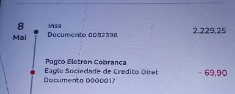 A imagem mostra a tela de um celular com um aplicativo aberto. O aplicativo exibe uma lista de transações ou serviços, com detalhes como nomes e valores. A parte superior da tela contém um cabeçalho, e a lista é organizada em linhas, cada uma com informações específicas. O fundo da tela é claro e o celular está apoiado em uma superfície com um padrão visível.