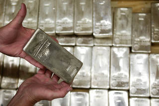 FILE PHOTO: An employee displays silver bars are pictured at the GSA company's headquarters in Vienna