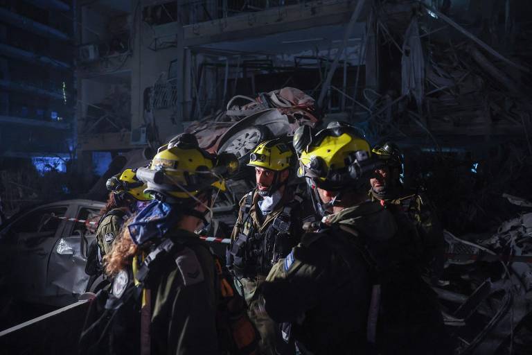Agentes das forças de segurança de Israel inspecionam local atingido por míssil iraniano em Ramat Gan, nos arredores de Tel Aviv