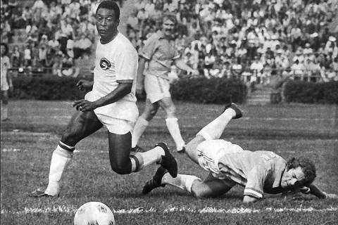 FILE  Pelé, left, in action during his debut game with the New York Cosmos, at Randalls Island Stadium in New York on June 15, 1975. One of soccers greatest players and a transformative figure in 20th-century sports who achieved a level of global celebrity few athletes have known, Pelé died on Thursday, Dec. 29, 2022, in São Paulo. He was 82. (Barton Silverman/The New York Times) ORG XMIT: XNYT147