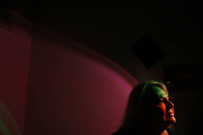 Imagem mostra retrato de uma mulher loira com fundo colorido