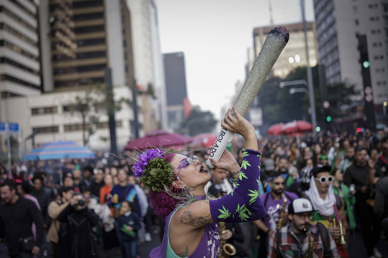 Manifestante segura balão inflável com formato de cigarro de maconha na avenida Paulista, em São Paulo; passeata de 2025 tem a intenção de denunciar os impactos da política de guerra às drogas sobre os mais vulneráveis, além de cobrar a legalização da cannabis