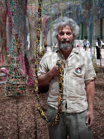 Brazilian artist Ernesto Neto poses for a photograph next to his art installation named 'Nosso Barco Tambor Terra' at the Grand Palais d'ete in Paris on June 10, 2025. (Photo by STEPHANE DE SAKUTIN / AFP) / RESTRICTED TO EDITORIAL USE - MANDATORY MENTION OF THE ARTIST UPON PUBLICATION - TO ILLUSTRATE THE EVENT AS SPECIFIED IN THE CAPTION