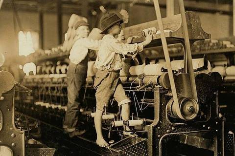 Meninos empregados em uma fábrica de fiação em Macon, Geórgia (EUA), em 1908. Alguns eram tão pequenos que precisavam subir na estrutura para arrumar fios e trocar bobinas