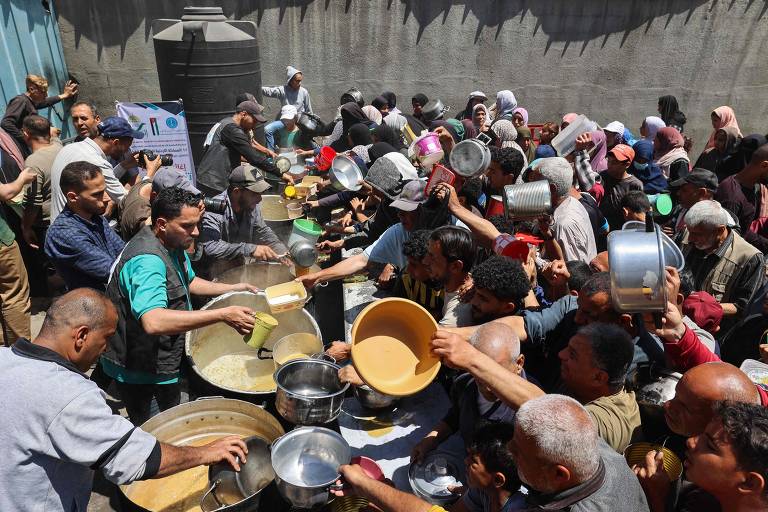 População com fome tenta conseguir porção de comida no campo de refugiados de Nuseirat