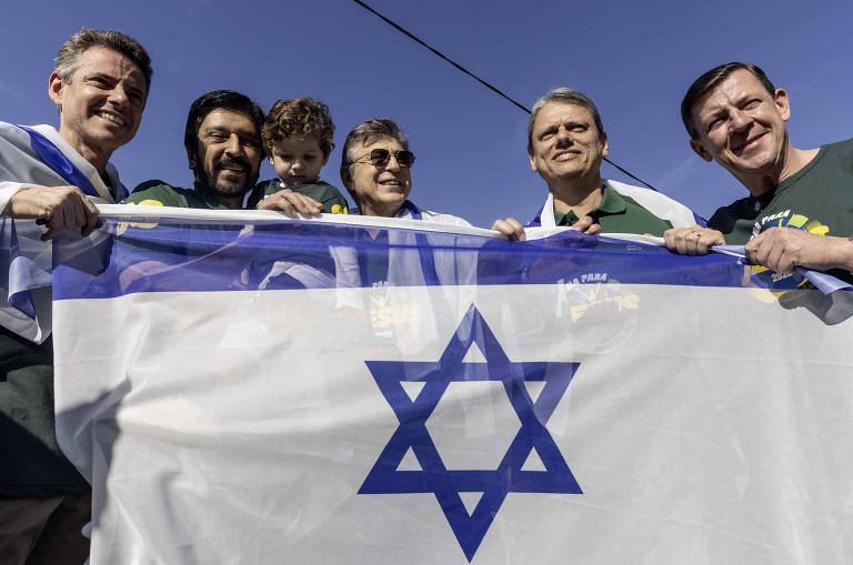 Prefeito Ricardo Nunes e Governador Tarcisio mostram bandeira de Israel durante a Marcha para Jesus