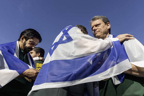 São Paulo, SP, BRASIL, 19/06/2025. Prefeito Ricardo Nunes e Governador Tarcisio se cobrem com   bandeira de Israel  no caminhão da Marcha para Jesus ,  na av Tiradentes  no centro de SP (foto:  Eduardo Knapp/Folhapress, COTIDIANO)