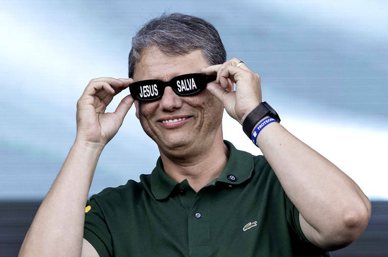 Governador Tarcisio de Freitas coloca óculos escrito Jesus Salva no palco da  Marcha para Jesus