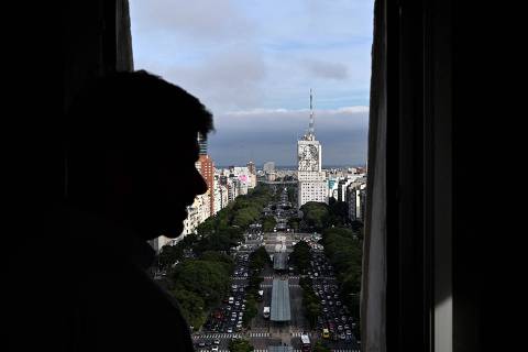 Juan Vacas, undersecretary of urban landscape for the city of Buenos Aires, looks down from the Obelisk observation deck in Buenos Aires on May 8, 2025. Buenos Aires' iconic Obelisk, a 67.5-meter monument that is the scene of Argentina's great celebrations, debuts a tourist elevator that will allow visitors and locals to access its summit with ease for the first time since its construction in 1936. (Photo by LUIS ROBAYO / AFP)
