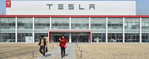 People walk outside the building of Teslas Xiedao delivery centre in Beijing on February 27, 2025. (Photo by ADEK BERRY / AFP)