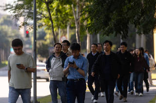 Funcionários da Huawei caminham em rua de São Paulo
