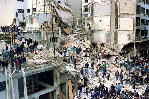 ORG XMIT: 114001_1.tif Equipe de resgate trabalha sobre escombros do prédio da Amia (Associação Mutual Israelita Argentina), em Buenos Aires, destruído por atentado, em 1994.   Rescue workers search for survivors and victims in the rubble left after a powerful car bomb destroyed the Buenos Aires headquarters of the Argentine Israeli Mutual Association (AMIA), killing 85 people, in this July 18, 1994 file photo. Police questioned and then released Iranian diplomat Saied Baghban in Brussels, Belgium, August 27, 2003, facing extradition to Argentina for the 1994 Jewish center bombing, but who has diplomatic immunity, 6 days after Iran's former ambassador to Argentina Hadi Soleimanpour was arrested in Durham, England, on an international warrant issued by Argentine Judge Juan Jose Galeano, provoking outcry from Iran's authorities. REUTERS/Enrique Marcarian/Files