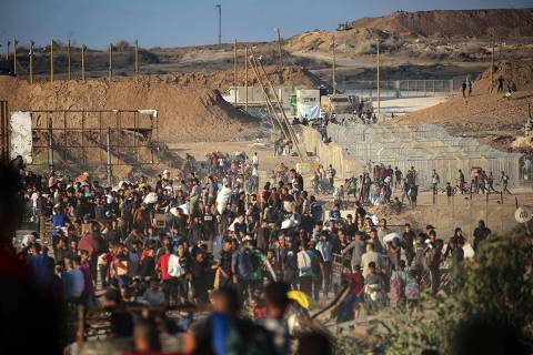 TOPSHOT - Palestinians gather at an aid distributution point set up by the privately-run Gaza Humanitarian Foundation (GHF), near the Nuseirat refugee camp in the central Gaza Strip on June 25, 2025. (Photo by Eyad BABA / AFP)