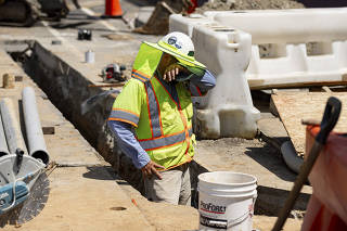 A construction worker wipes sweat from his face during a heat wave in Washington, June 24, 2025. (Wesley Lapointe/The New York Times)