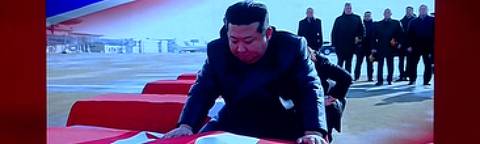 Telão mostra Kim Jong-un colocando a bandeira norte-coreana em caixões de soldados mortos lutando pela Rússia