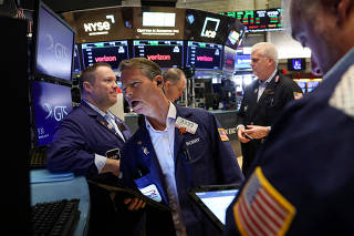 Traders work on the floor of the NYSE in New York