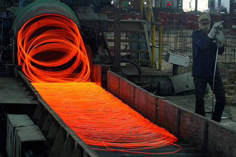 FILE PHOTO: A labourer works inside a steel factory in the northern Indian city of Kanpur July 20, 2009. REUTERS/Pawan Kumar (INDIA BUSINESS)/File Photo ORG XMIT: FW1