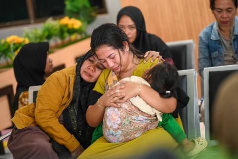 Family members and relatives wait for updates on the search operation of at least 61 people who were missing after a ferry sank off the popular Indonesian resort island of Bali, at Ketapang Port in Banyuwangi, East Java on July 3, 2025. (Photo by AFP)