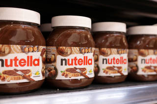 Jars of Nutella are displayed on a shelf in a supermarket