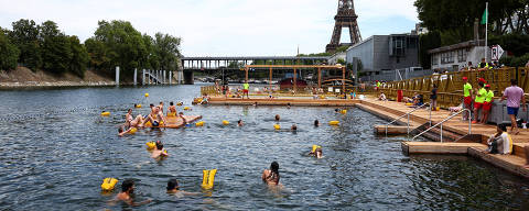 People swim in the River Seine with the Eiffel tower in the background at the Grenelle site, opened to swimmers marking the first public bathing session in the capital's historic waterway, in Paris, France, July 5, 2025. REUTERS/Abdul Saboor ORG XMIT: LIVE