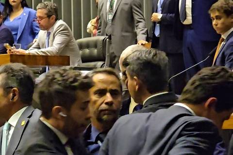 Plenário da Câmara tem tumulto em torno de tarifaço de Trump envolvendo os deputados Nikolas Ferreira (na tribuna) e André Janones (sendo contido pela polícia legislativa)
