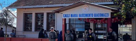 Police officers stand guard at the entrance of the Municipal School Maria Nascimento Giacomazzi after a 16-year-old teenager entered the school, killed a child, and wounded two people in Estacao, Rio Grande do Sul State, Brazil, on July 8, 2025. (Photo by Andrei NARDI / Grupo Sideral de Radios / AFP)