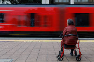 An elderly person waits for public transit in San Diego