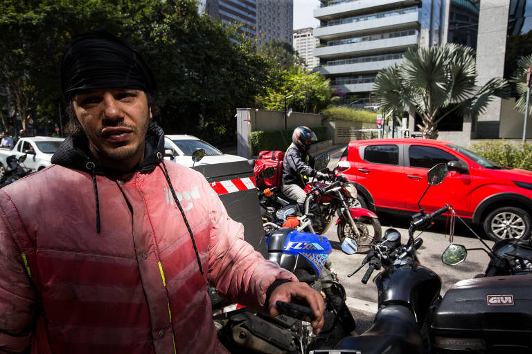 A imagem mostra um homem com toca na cabeça ao lado de motocicletas estacionadas