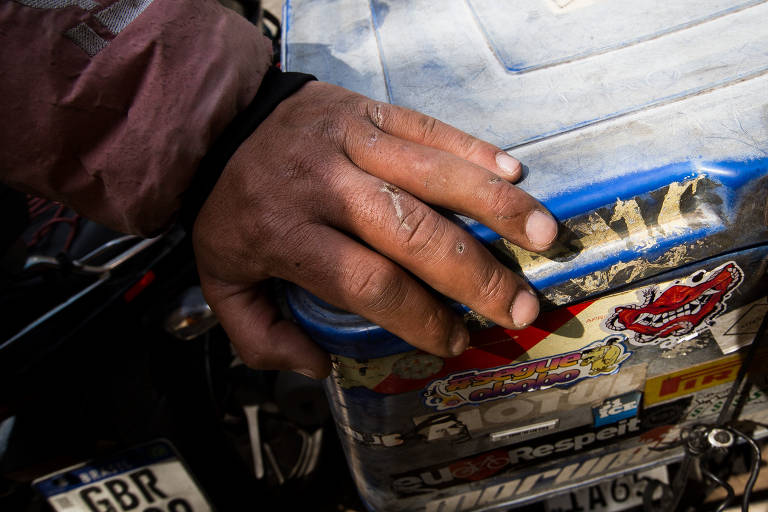 Motoboy Fernando Salu, 36, mostra machucados na mão causados por colisão recente com retrovisor de um carro