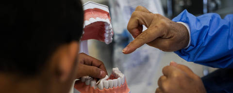 SAO PAULOS/ SP, BRASIL, 05-05-2023:  O paciente, Carlos de 13 anos, aprende como fazer a higiene bucal durante  atendimento odontologico com a auxiliar bucal Dalva Candida Ribeiro, 59,, na UBC Cambuci.   (Foto: Zanone Fraissat/Folhapress, EQUILIBRIO)***EXCLUSIVO****