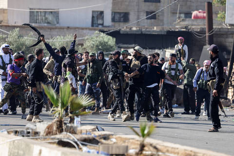 Internal Security Forces officers escort a Druze prisoner and prevent him from being attacked by Bedouins, at an Internal Security Forces checkpoint working to prevent Bedouin fighters from advancing towards Sweida, following renewed fighting between Bedouin fighters and Druze gunmen, despite an announced truce, in Walgha, Sweida province, Syria July 19, 2025. REUTERS/Khalil Ashawi ORG XMIT: LIVE