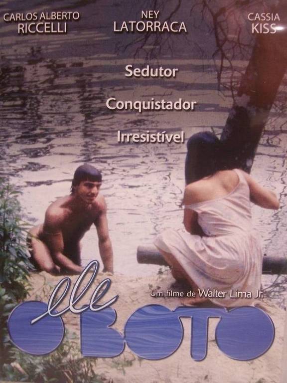 O pôster do filme "O Boto" apresenta duas figuras humanas em um ambiente natural, possivelmente à beira de um rio. Um homem está sentado na margem, com uma expressão sedutora, enquanto uma mulher está de costas, olhando para a água. O título do filme, "O Boto", está em destaque na parte inferior, com o texto em uma fonte estilizada. Acima, estão os nomes dos atores Carlos Alberto Riccelli, Ney Latorraca e Cassia Kiss, seguidos de palavras como 'Sedutor', 'Conquistador' e 'Irresistível'.