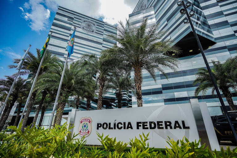 L'immagine mostra la sede centrale della Polizia Federale Brasiliana, un edificio moderno con una facciata grigia e nera. Sulla facciata dell'edificio c'è un cartello con la scritta