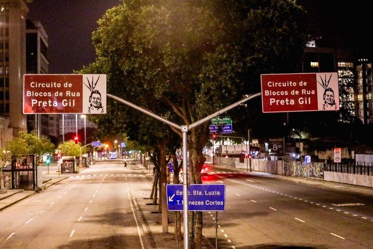 The image shows a street intersection at night, with road signs indicating the