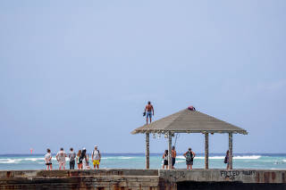 Vacationers return to beaches after tsunami warnings were downgraded in Honolulu