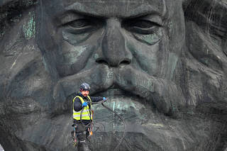 A worker walks in front of the Karl Marx monument, known as the ?Nischel? before the opening ceremony as European Capital of Culture in Chemnitz