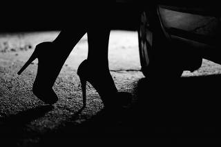 Silhouette of female legs in high heels coming to car, prostitution, sex tourism